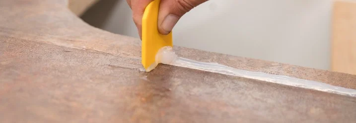 Hand verteilt Dichtmittel mit Spachtel